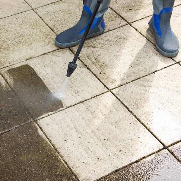 A cleaner pressure washing paving slabs clean