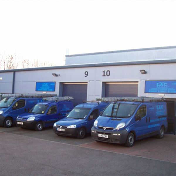 LAC Cleaning Contractors Blue vans in front of building